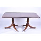 A Regency mahogany extending dining table  with extra leaf, the twin-pedestal bases on tapering