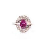 An Italian white gold, diamond, and gemstone ring centred with a mixed oval-cut red gemstone (