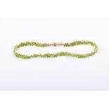 A faceted peridot bead necklace comprised of briolette-cut beads, fastened with a gilt metal clasp.