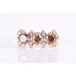 A white and cognac diamond ring set with three round-cut cognac diamonds with eight small round-