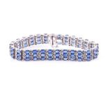 A 14ct white gold, diamond, and sapphire bracelet set with alternating rows of mixed oval-cut blue