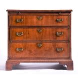 A small Georgian straight fronted walnut chest of drawers with quarter veneered top and pull out