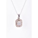 An 18 carat white gold and diamond pendant the rectangular mount centered with an emerald-cut