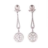 A pair of diamond drop earrings each with a double loop mount inset with a round brilliant-cut