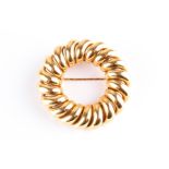 A yellow metal wreath-shaped brooch of looped design, bearing makers mark of a D with an arrow,