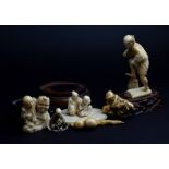 Two Japanese carved ivory netsukes Meiji period, one modelled as a seated man holding an animal on a