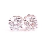 A pair of diamond solitaire ear studs set with two round brilliant-cut diamonds of approximately 1.0