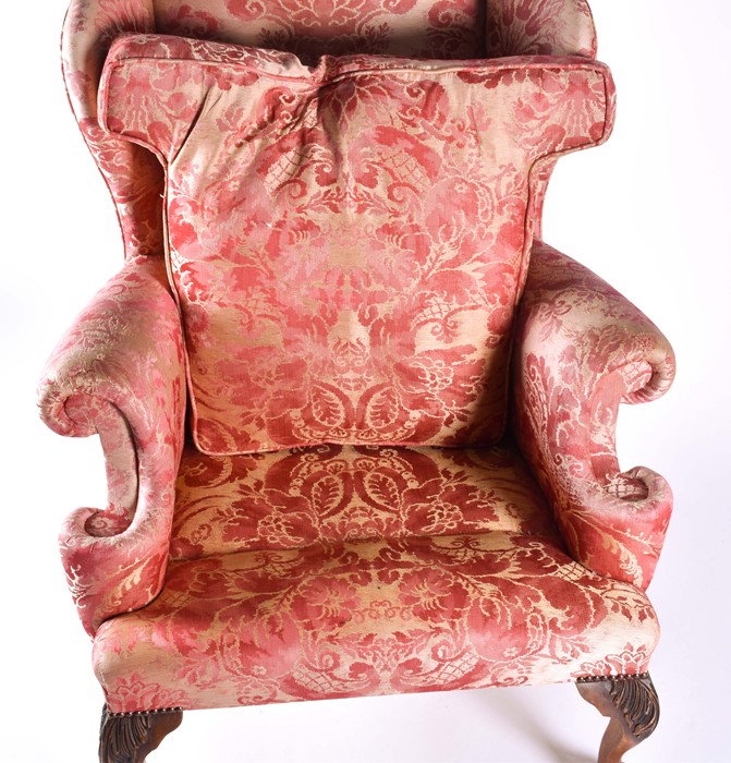 An English upholstered wingback armchair with pink rococo design fabric with studded metal detail to - Image 4 of 5