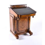 A Victorian walnut and ebonised wood Davenport the top with frieze drawer, over an inset tooled