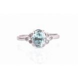 A blue zircon and white stone ring centred with a mixed oval-cut natural zircon, flanked with