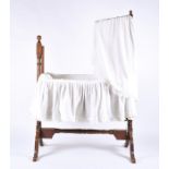 A Victorian rocking crib with swinging pole to attach the hooded fabric, with turned finials, raised