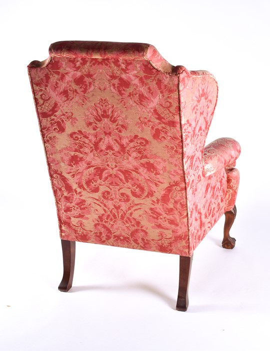 An English upholstered wingback armchair with pink rococo design fabric with studded metal detail to - Image 5 of 5