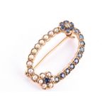 A 9ct yellow gold, sapphire, and split seed pearl brooch the openwork oval mount decorated with