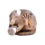 A fine Japanese ivory netsuke modelled as a rat Meiji period, its front paws clutching a piece of