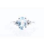 A 9ct white gold, diamond, and aquamarine ring set with an oval-cut aquamarine flanked with two