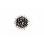 An 18ct yellow gold and black and white diamond cluster ring set with a central stepped cluster of