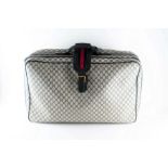 Gucci. A vintage suitcase  made of woven monogram material with leather handles and zips,