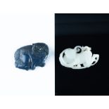 A Chinese white jade carving of a young boy 7.5 cm long, together with a lapis carving of a dog of