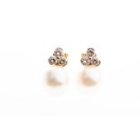 A pair of diamond and pearl earrings each set with three round brilliant-cut diamonds of