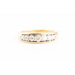 An 18ct yellow gold and diamond ring channel-set with seven graduated round brilliant-cut diamonds