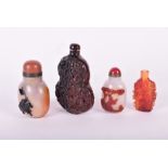 Two Chinese carved agate snuff bottles along  both relief carved, along with a relief carved