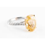 An impressive 18ct white gold, diamond, and yellow sapphire ring set with a mixed oval-cut