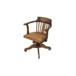 An early 20th century oak captain's chair with studded leather seat, on quatrefoil base, 61 cm