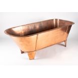 A late 19th or early 20th century copper bathtub with brass plumbing mounts, 65 cm high x 176 cm x