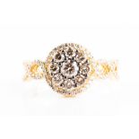 A white and cognac diamond floral ring set with a floral cluster of round brilliant-cut pale