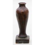 Kleine Vase.Bronze. Glatter, lang gestreckt gebauchter KOrpus, auf quadratischem Stand (l. besch.)