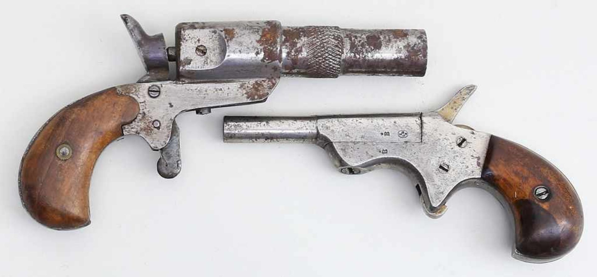 2 Taschenpistolen, so genannte "Flobert"-Art.Eisen (rostig). Holzschaft. gem. D.RG.M., um 1900. L.