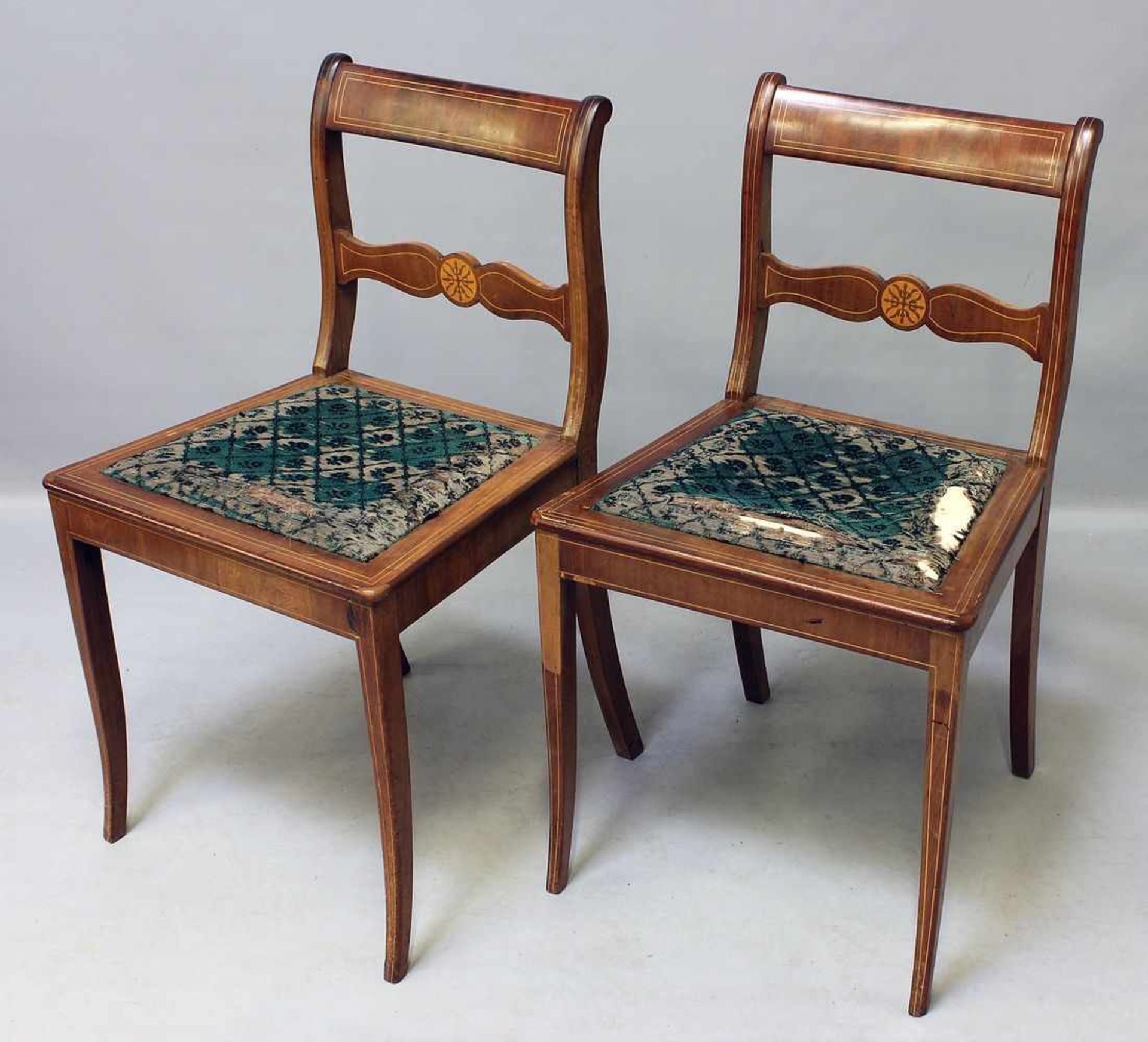 Paar Tafelstühle.Mahagoni-Furnier mit Fadeneinlage. Schmale Säbelbeine, rückwärtig in leicht