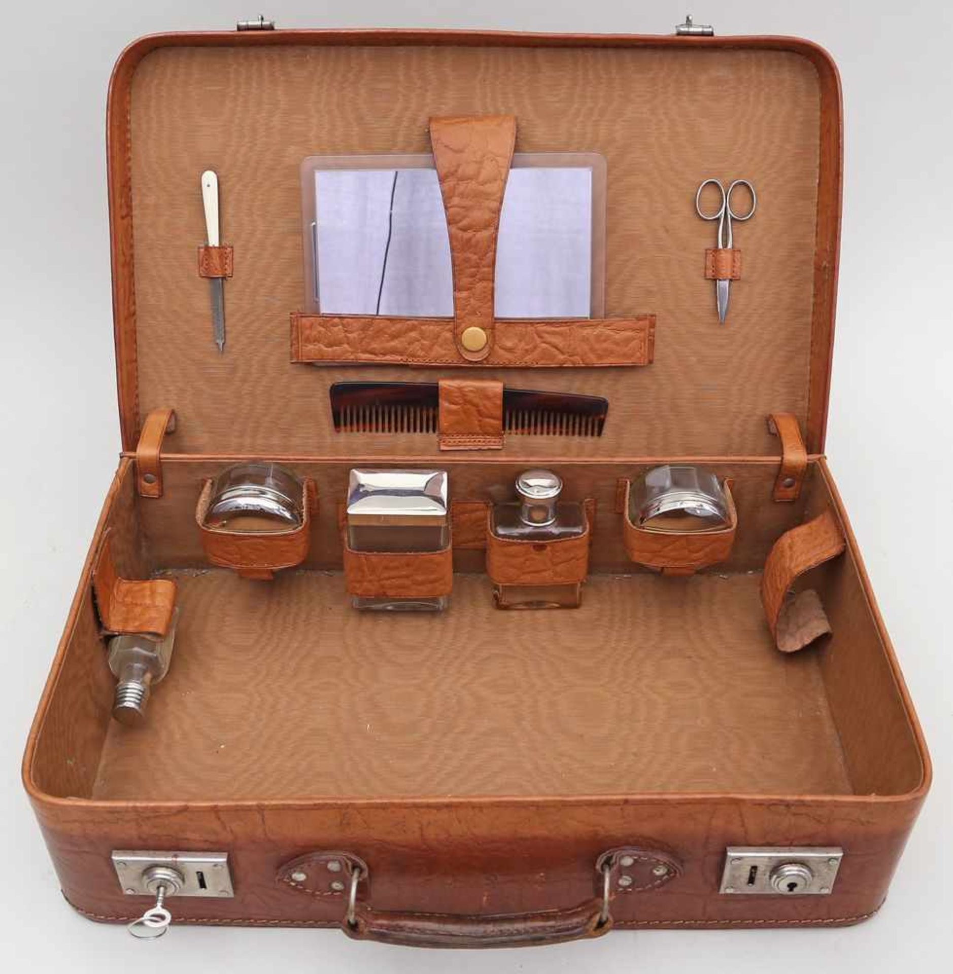 Koffer mit Reisetoilette.Braunes Kunstleder. Innen mit 9 verschiedenen Utensilien. Schlüssel