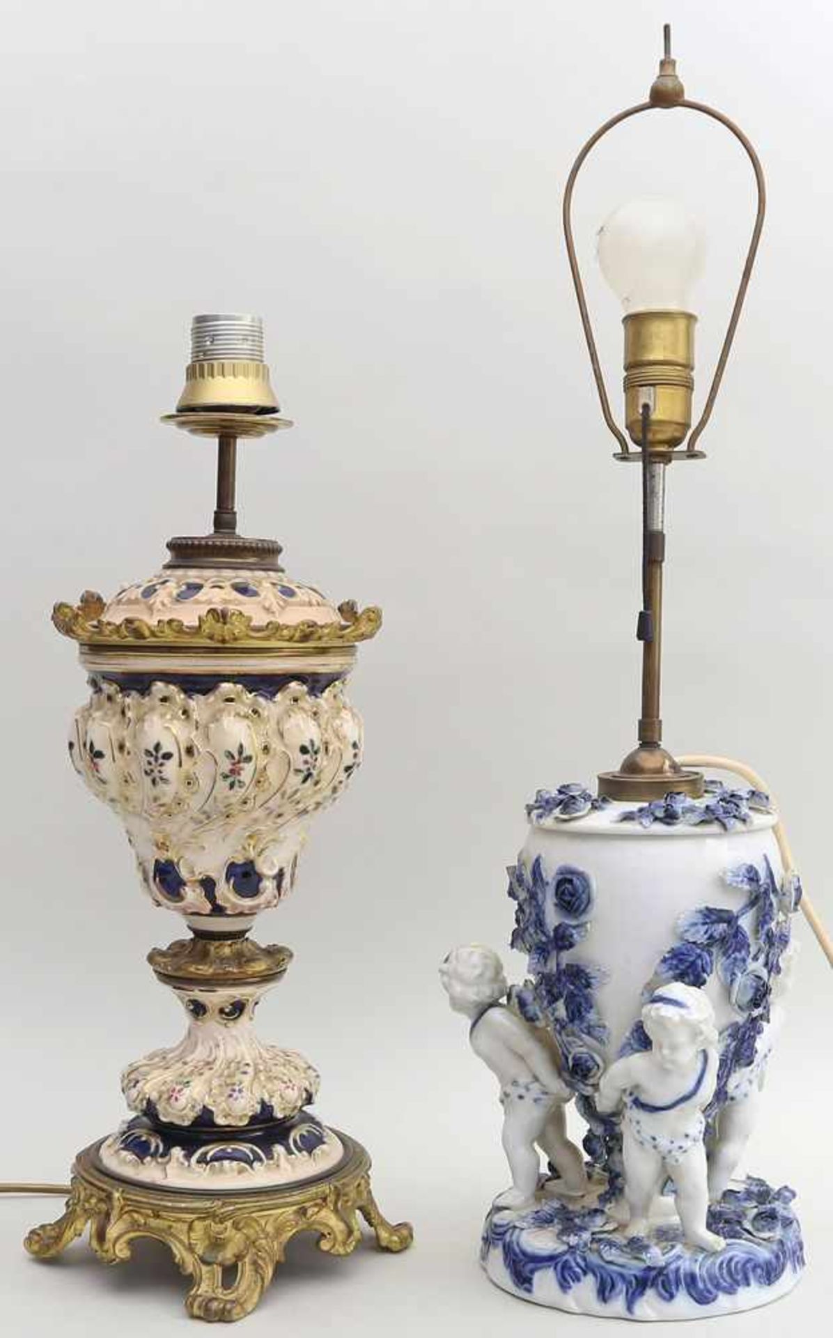 2 Tischleuchten, um 1900.Porzellan/Keramik mit Blaudekor. 1x figürlicher Sockel mit 3 Putten. Besch.
