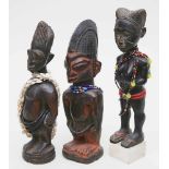Drei afrikanische Skulpturen.Männliche und weibliche Darstellungen mit Glasperlenbehang. Dabei