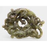 Ringscheibe.Grüne Jade mit dunkelbraunen Partien. Archaisierendes Dekor mit drei plastischen