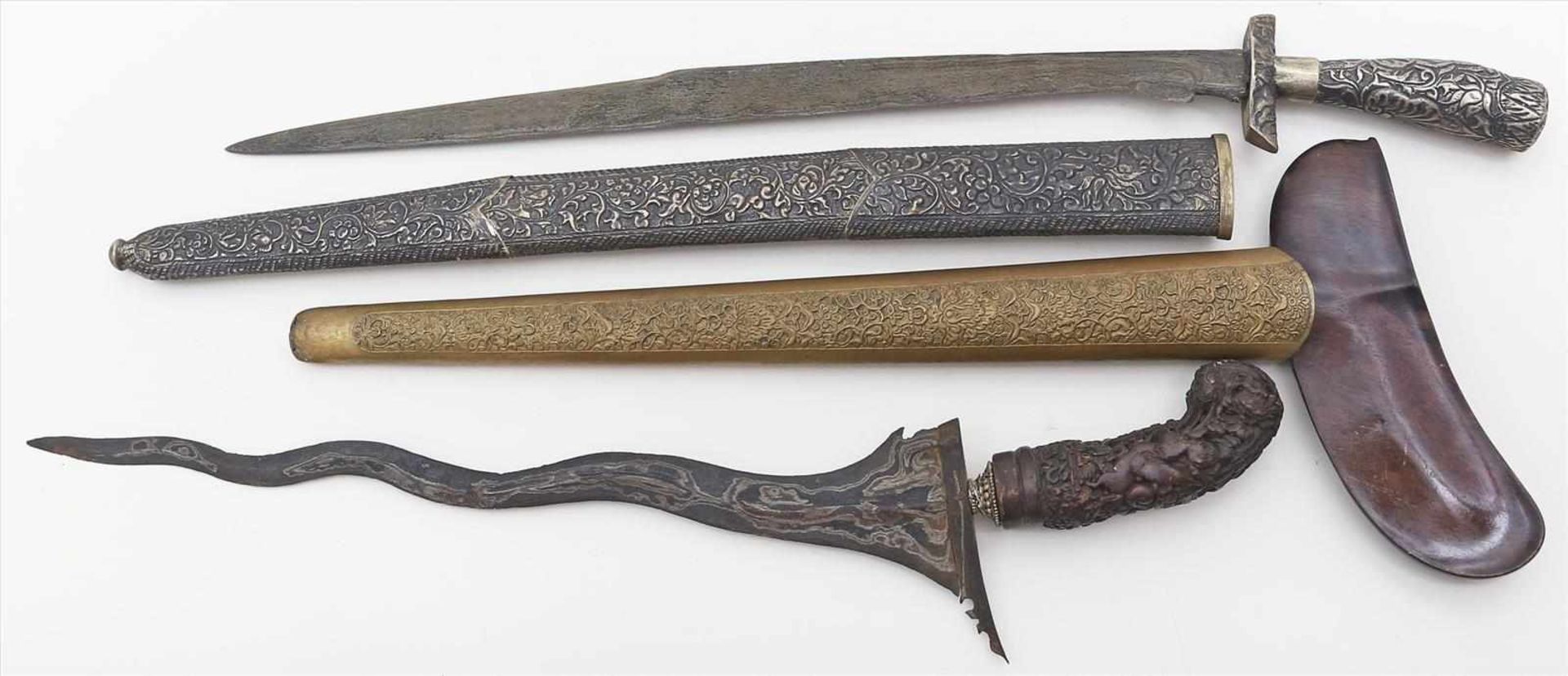 2 Messer bzw. Dolche.Metall, 1x mit geschnitztem Holzgriff, Scheiden mit reliefiertem Dekor. Teils