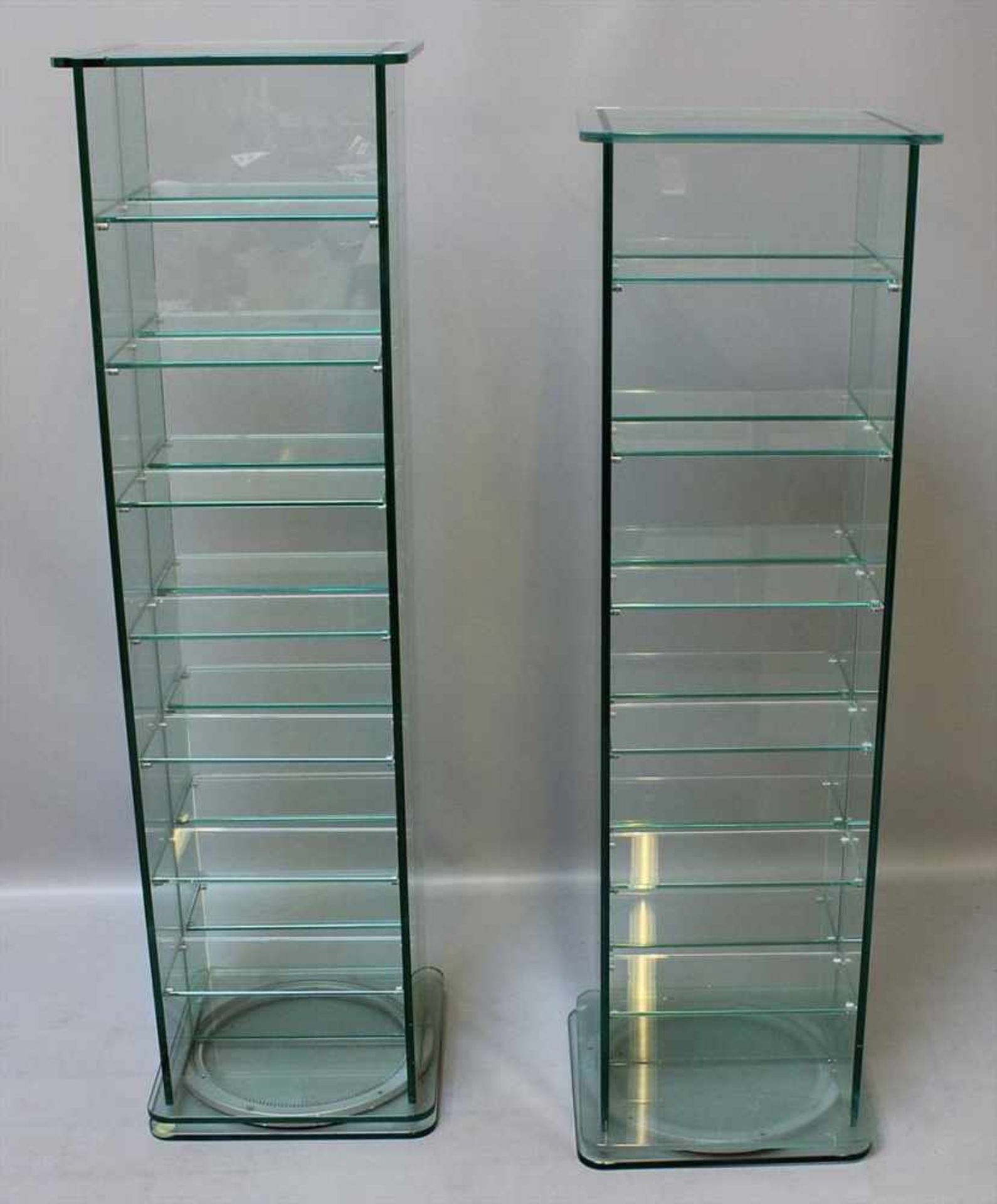 2 CD-Regale.Glas, drehbar. L. Alters- und Gebrauchsspuren. 20. Jh. Ca. 116 bzw. 123x 35x 35 cm.