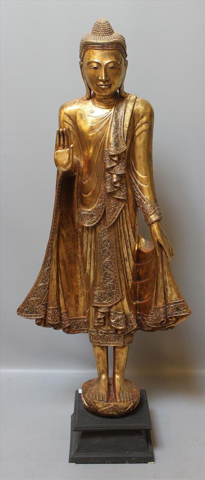Große, dekorative Buddhaskulptur.Vergoldetes Holz mit Glasbesatz. Auf ebonisierten Holzsockel.