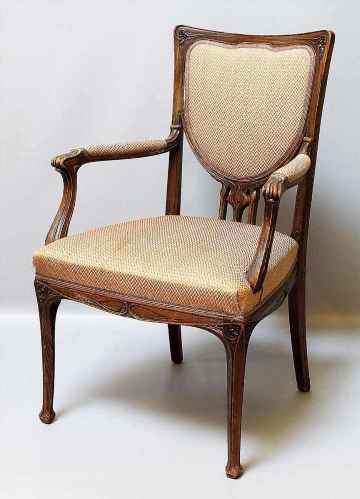 Jugendstil-Armlehnstuhl.Hölzernes Gestell mit reliefiertem Dekor. Sitzfläche und Rückenlehne mit