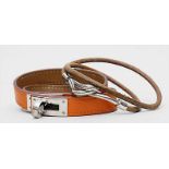 Zwei Lederarmbänder, Hermès.a) Armband "Kelly Double" in Orange/Silber. Gem. Hermés. L. 36 cmund