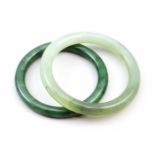 Zwei Jadearmreife.Gewölkte Jade in verschiedenen Grüntönen. B. 0,8 bzw. 0,9 cm, D. 6 bzw. 6,2 cm.- -