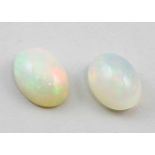 Paar weiße Opale, zus. 10,42 ct.Ovale Cabochons. Gelartige Struktur, lebhaftes Farbenspiel in
