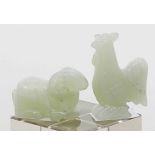 Zwei Jadeskulpturen.Hellgrüne Jade. Liegender Widder und stehender Hahn. China. H. 2,5 bzw. 5 cm.- -