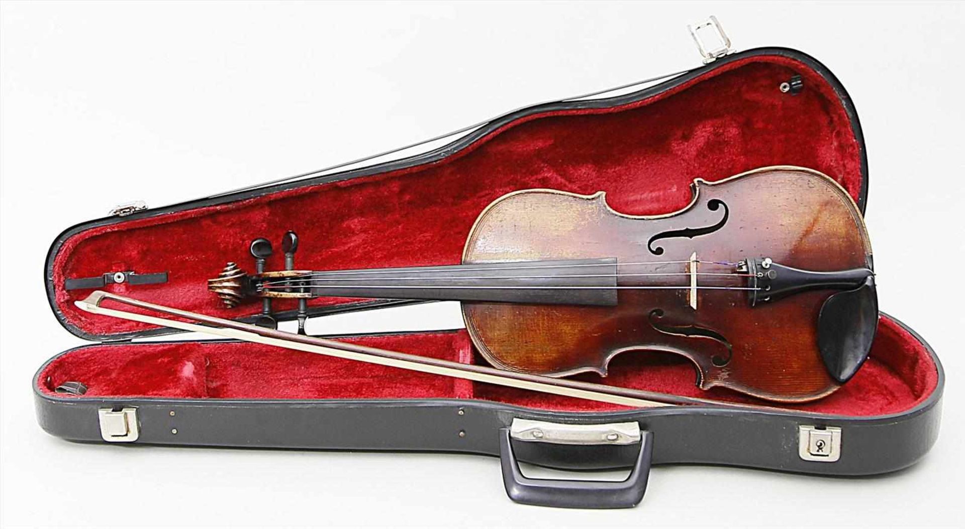 Violine mit Bogen.Holzkorpus mit Gebrauchsspuren. Innen Pseudo-Etikett "...Paolo Maggini". L. 60 cm.