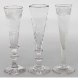 Drei Sektgläser.Farbloses Glas. Unterschiedliche Formen und Schliffdekore. Um 1820-1830. H. ca. 19