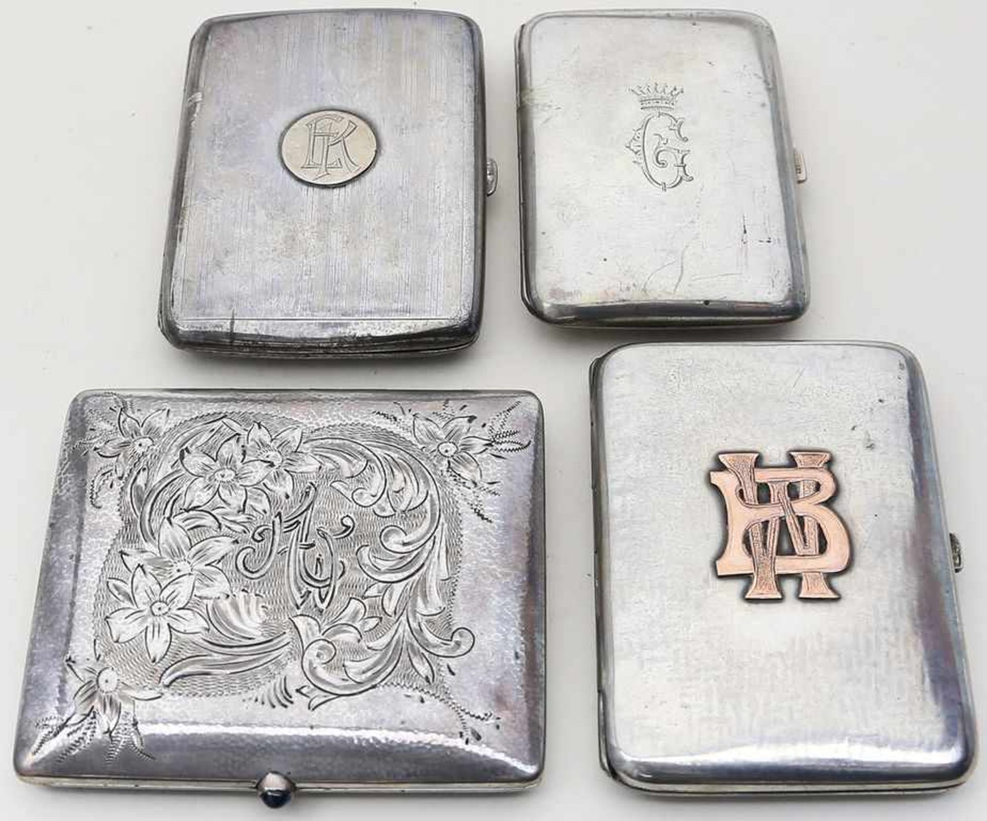4 Zigarrettenetuis.Silber, ca. 330 g. Verschiedene Reliefdekore, einmal Drücker mit blauem