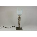 Art Deco tafellampje op smeedijzeren voet en iriserend kapje met reliefdecor, h. 38 cm.
