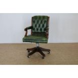 Noten Captains chair met groen leer bekleed.