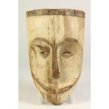 Houten gestoken Tsogho masker met vierkante spleetogen en gesloten mond, Gabon, l. 30 cm.Wooden